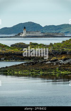 Vista del faro di Fladda dall'isola di Luing vicino a Oban, Argyll, Scozia, Regno Unito Foto Stock