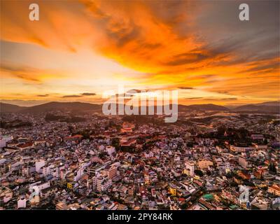 Radioso skyline al tramonto: Accattivante vista del cielo rosso della città di da Lat, Vietnam, con una splendida miscela di colori tra il paesaggio urbano e il cielo al tramonto Foto Stock