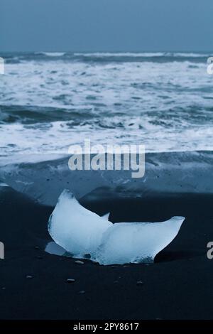 Primo piano pezzi di ghiaccio sulla sabbia nera Concept foto Foto Stock