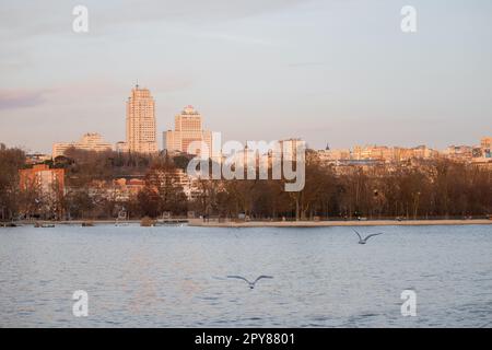 Vista panoramica sul lago Casa de campo di Madrid al tramonto con alcuni hotel sullo sfondo Foto Stock