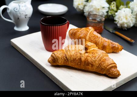 croissant appena sfornati e tazza di caffè sul tavolo, vista dall'alto Foto Stock