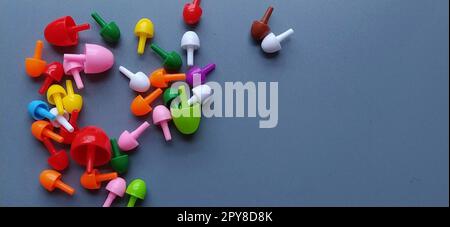 Gioco da tavolo - un mosaico per lo sviluppo delle capacità mentali e creative del bambino. Sfondo grigio con spazio libero per il testo. A sinistra, chip e moduli multicolore per creare un grafico Foto Stock