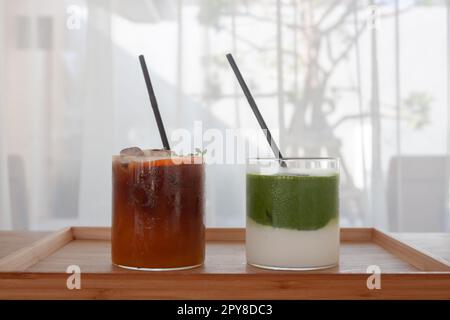 Americano ghiacciato con arancia e tè verde matcha freddo al bar Foto Stock