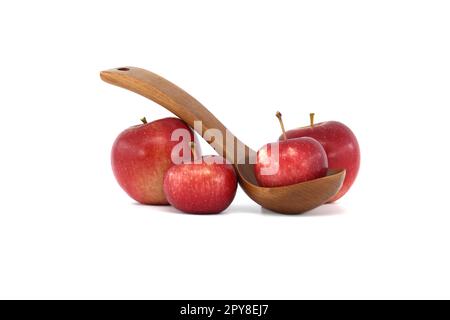 Mele rosse, una posta in un cucchiaio di legno intagliato Foto Stock