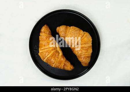 croissant appena sfornati e tazza di caffè su sfondo bianco, vista dall'alto Foto Stock