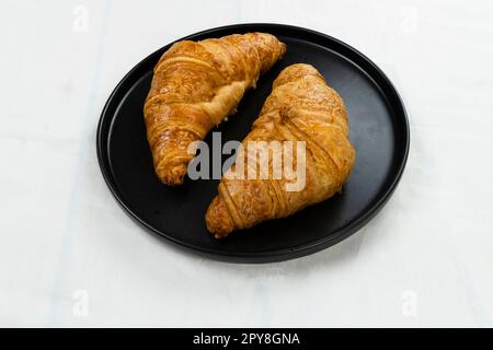 croissant appena sfornati e tazza di caffè su sfondo bianco, vista dall'alto Foto Stock