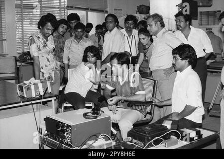 Indian Old vintage 1980s bianco e nero bollywood cinema hindi film attore, India, folla guardando partita TV, India Foto Stock