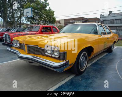 Lanus, Argentina - 24 settembre 2022: Vecchio 1973 Pontiac Catalina 400 quattro porte berlina taxi giallo in un parco. Natura, alberi. Spettacolo di auto classica AAA 2022. Foto Stock