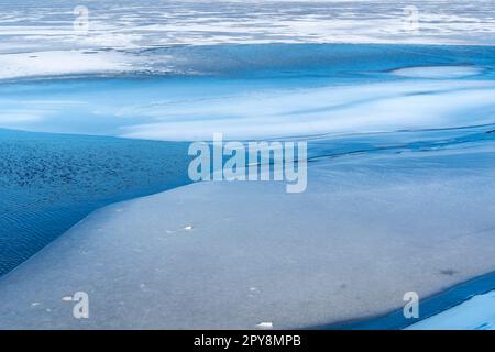 Buchi di ghiaccio che scioglie sul lago Foto Stock