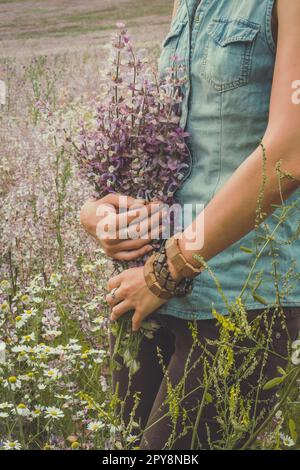 Signora con bouquet di fiori di vento in campo fotografia panoramica Foto Stock