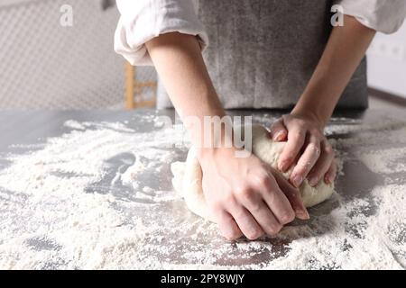 Donna impastare a tavola in cucina, primo piano Foto Stock