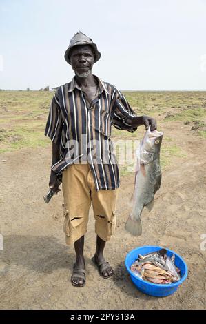 KENYA, Turkana, villaggio Anam al Lago Turkana, pescatore con il Nilo persico / KENIA, Turkana, Dorf Anam Lago Turkana, Fischer Foto Stock