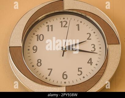 Round orologio da parete mostra il tempo di 2 ore e 15 minuti sul quadrante di luce Foto Stock
