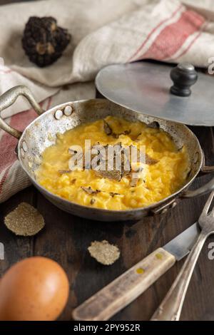 Uova strapazzate con tartufi neri freschi italiani serviti in padella, colazione da buongustai Foto Stock