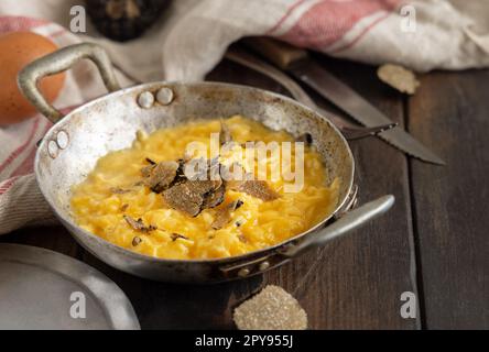 Uova strapazzate con tartufi neri freschi italiani serviti in padella, colazione da buongustai Foto Stock