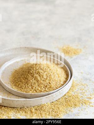 Grano bulgur secco crudo su una piastra, primo piano, spazio di copia. Cucina vegetariana e mediorientale Foto Stock