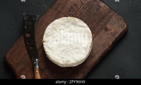 Formaggio Camembert de Normandie sul tagliere con coltello Foto Stock