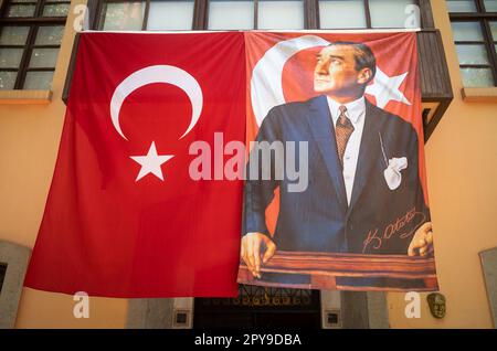 Una bandiera turca e uno striscione di pari dimensioni con un ritratto di Mustafa Kemal Ataturk sopra l'entrata di un centro della storia patriottica della Turchia A. Foto Stock