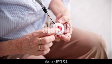 Senior donna premendo il pulsante di allarme Foto Stock