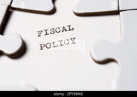 Testo della politica fiscale scritto con una macchina da scrivere in un puzzle bianco Foto Stock