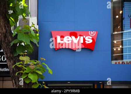 Ho Chi Minh City, Vietnam - 1 maggio 2023: Segno commerciale del negozio di jeans denim con un logo Levi rosso. Famosa insegna di abbigliamento sopra l'ingresso di un negozio Foto Stock