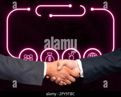 Due uomini in tuta che stringono la mano davanti a uno sfondo futuristico con bagliore colorato. Nuove tecnologie digitali del futuro. La stretta di mano rappresenta un accordo. Foto Stock