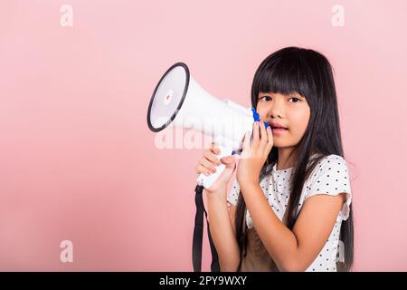 Ragazzino asiatico di 10 anni urla dal megafono Foto Stock