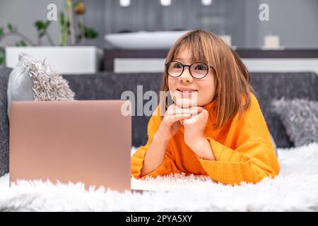 i bambini utilizzano un notebook a casa per l'apprendimento e l'intrattenimento online Foto Stock