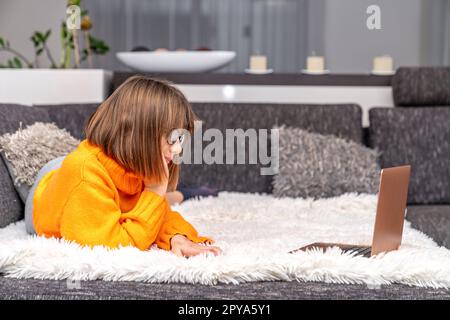 i bambini utilizzano un notebook a casa per l'apprendimento e l'intrattenimento online Foto Stock