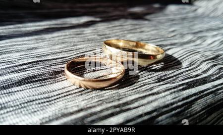 Due anelli d'oro su sfondo grigio per cerimonia Foto Stock