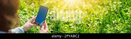 Donna che tiene in mano lo smartphone con schermo nero vuoto. Foto Stock