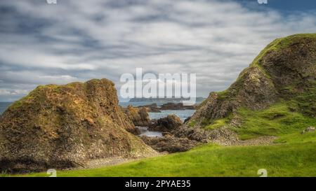 Splendida costa con colline, scogliere e piccole isole rocciose sulla Causeway Coast Foto Stock