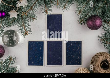 Carte di tarocchi spalmate su una superficie bianca di cemento con rami di alberi di Natale e candele. Minsk, Bielorussia, 19.11.2021 Foto Stock