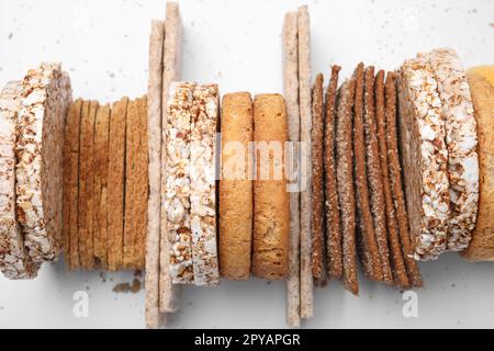 Molte crocchette di segale fresche, torte di riso croccanti e fette biscottate su sfondo bianco, vista dall'alto Foto Stock