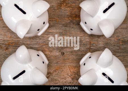 Quattro salvadanaio sul vecchio sfondo di legno Foto Stock