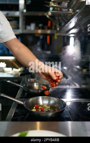 Lo chef prepara la salsa di pomodoro per la pasta nella padella Foto Stock