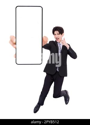 Giovane uomo d'affari che salta e mostra lo schermo vuoto del telefono cellulare Foto Stock