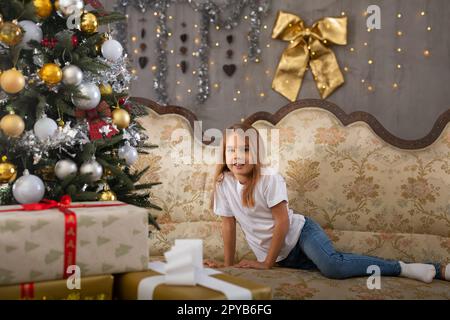 Bambina sul divano in studio con interni natalizi Foto Stock