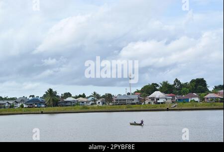 Pescatore in barca sul fiume Kuching. Foto Stock