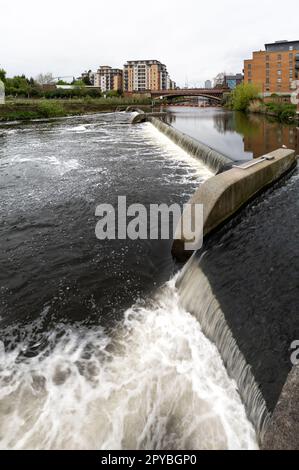 Vista panoramica verticale dell'acqua che scorre sullo stramazzo e trabocca sul fiume Aire al Leeds Dock Foto Stock