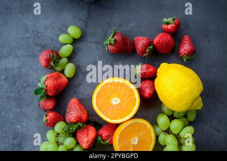 Frutta e bacche varie su fondo di pietra scura Foto Stock