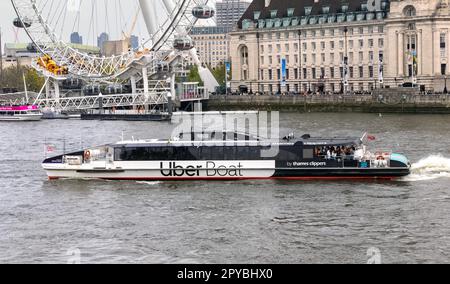 UberBoat da diporto di Thames Clippers pieno di turisti che passano oltre il London Eye Westminster 30th aprile 2023 Foto Stock