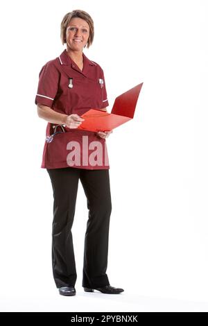 Professionisti della salute: Infermiere. Ritratto completo studio su bianco di una operatrice medica in uniforme consultando le sue note. Da una serie di immagini correlate. Foto Stock
