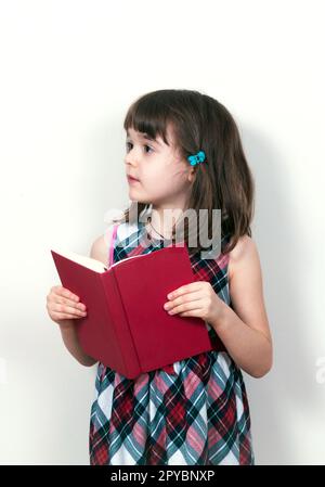 Bambina la lettura di un libro a casa Foto Stock