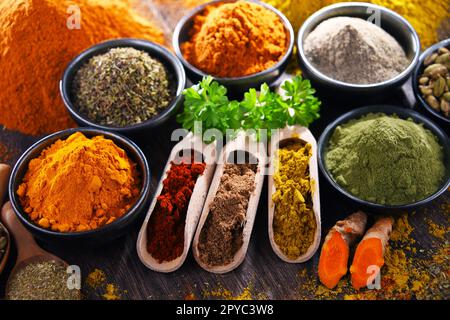 Varietà di spezie su tavolo da cucina in legno Foto stock - Alamy