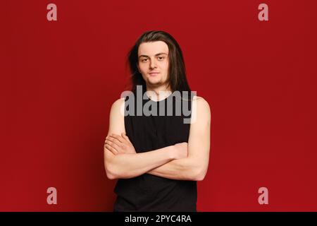Ritratto in studio di un giovane uomo bello con lunghi capelli neri Foto Stock