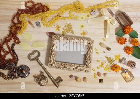 Gioielli e decorazioni gialli e marroni con chiave in ottone vintage e cornice fotografica Foto Stock