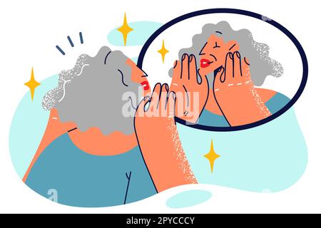 Donna anziana guarda nello specchio sensazione di gioia delle rughe dopo l'applicazione di crema anti-invecchiamento o andare a estetista. vecchia donna con i capelli grigi si prende cura di f Foto Stock