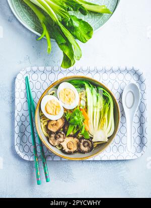 Zuppa di ramen con funghi shiitake, verdure, tagliatelle e uova Foto Stock
