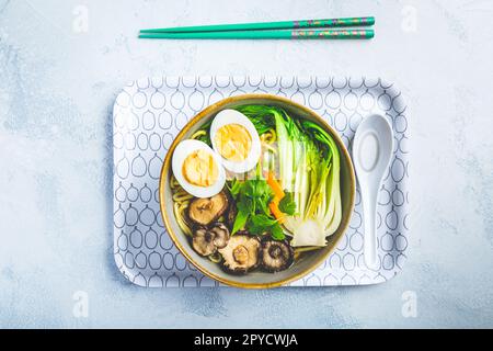 Zuppa di ramen con funghi shiitake, verdure, tagliatelle e uova Foto Stock